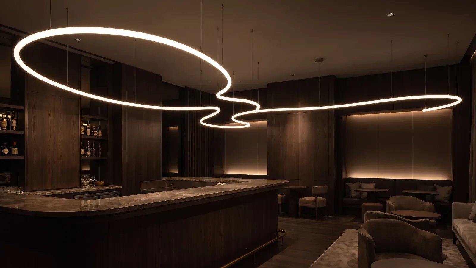 Bar de hotel en penumbra, de madera oscura, con un tubo de luz cálida suspendido de cables finos que forma curvas continuas sobre la barra de piedra.
